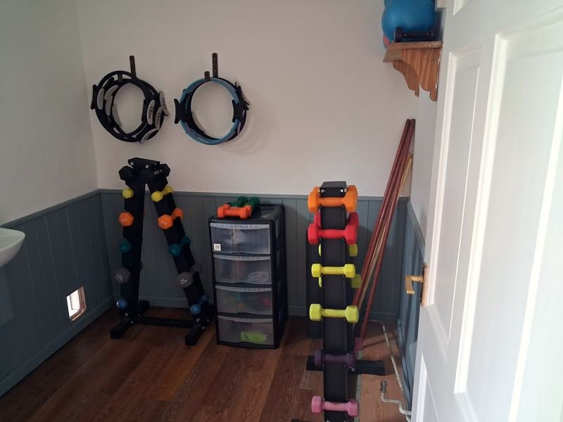 Pilates rings, dumbbells and resistance bands stored on the studio wall
